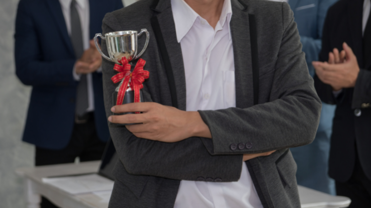 a man holding an employee award trophy
